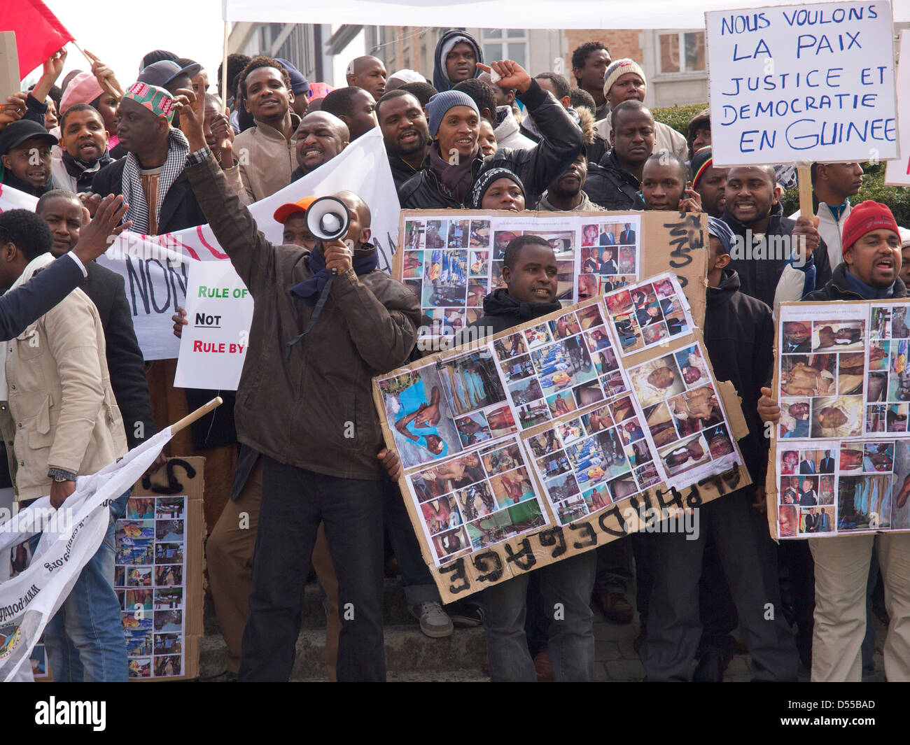 People protesting against dictator Alpha Conde of Guinea with signs with pictures of tortured victims. Brussels, Belgium Stock Photo