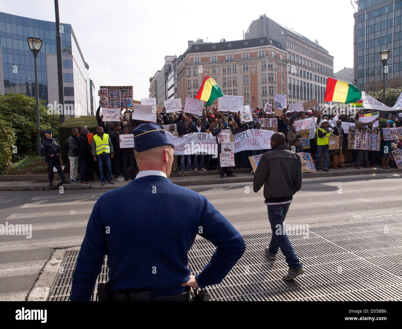 People protesting against dictator Alpha Conde of Guinea with Belgian policeman watching them. Schuman, Brussels, Belgium Stock Photo