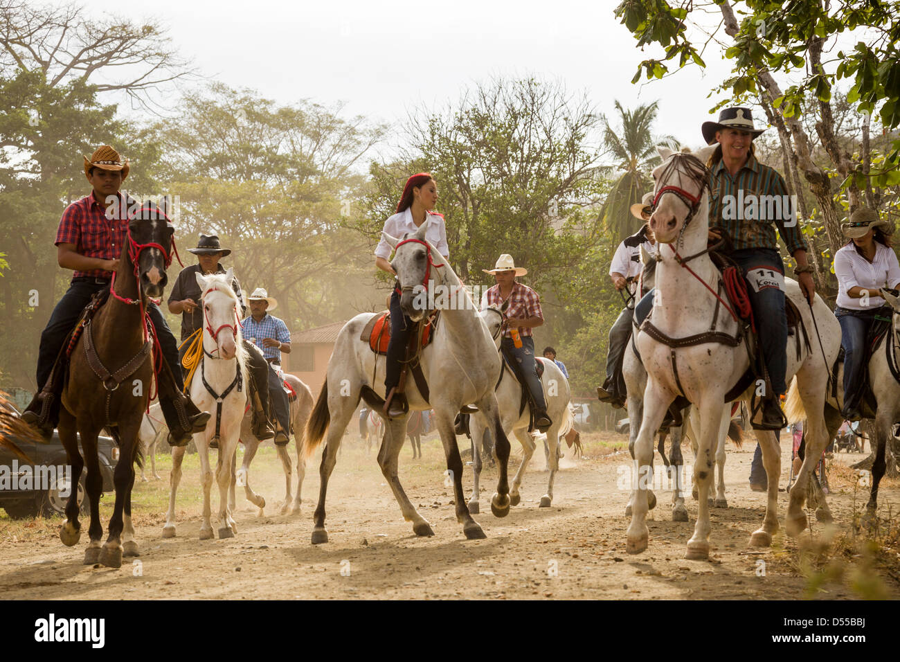 Riding horses through town during the Tope de Caballos at Coco Beach, Playas del Coco, Guanacaste, Costa Rica. Stock Photo