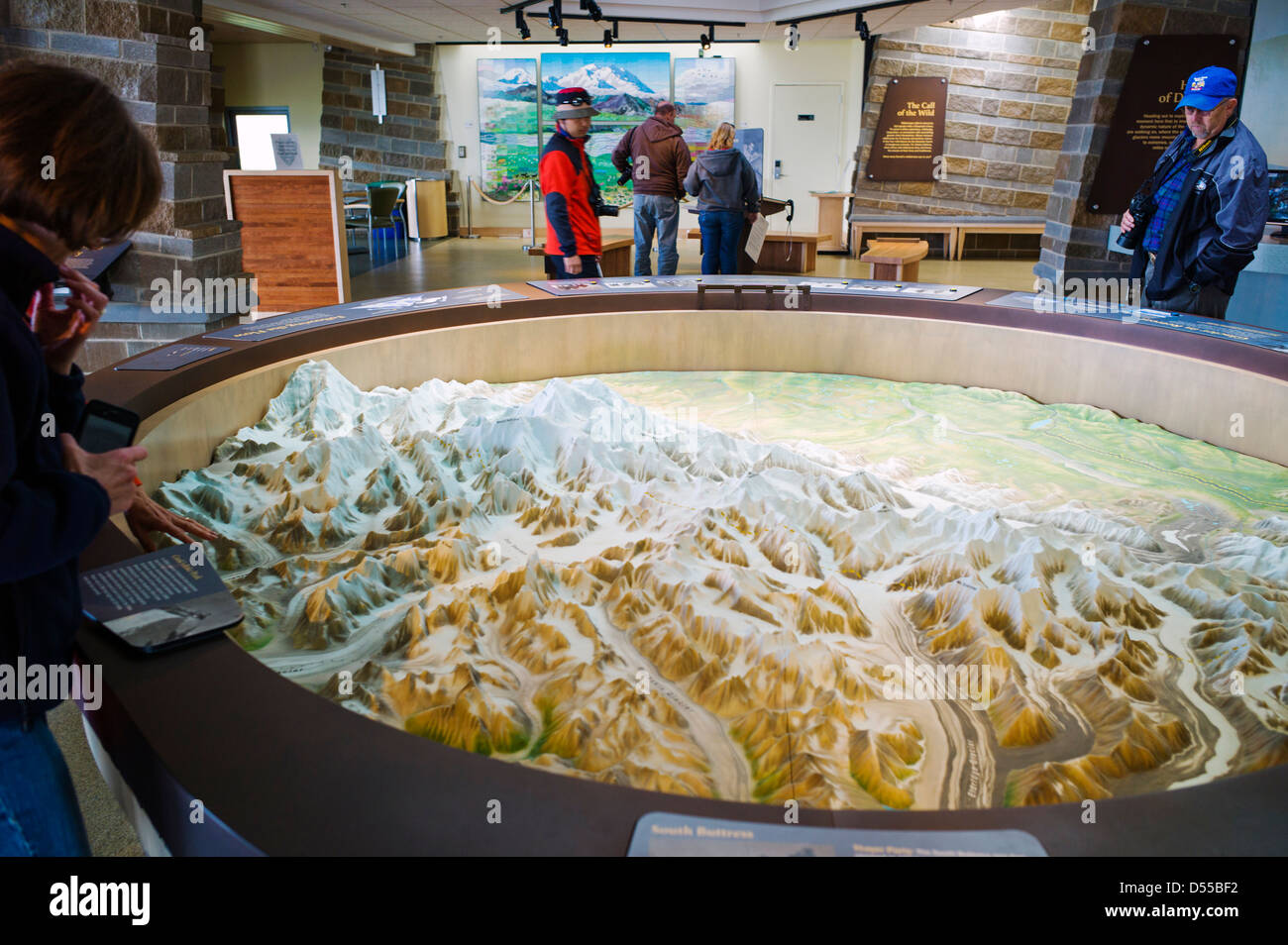 Park visitors view a three dimensional topographical map on display, Eielson Visitor Center, Denali National Park, Alaska, USA Stock Photo