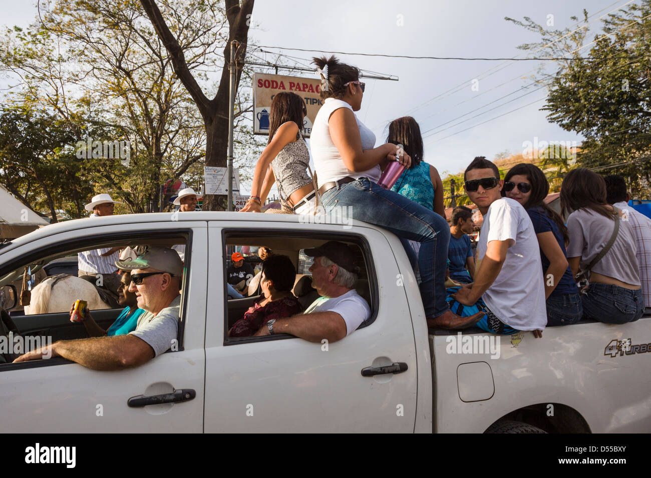 Teenagers riding back of pickup truck during a parade at Coco Beach, Playas del Coco, Guanacaste, Costa Rica. Stock Photo
