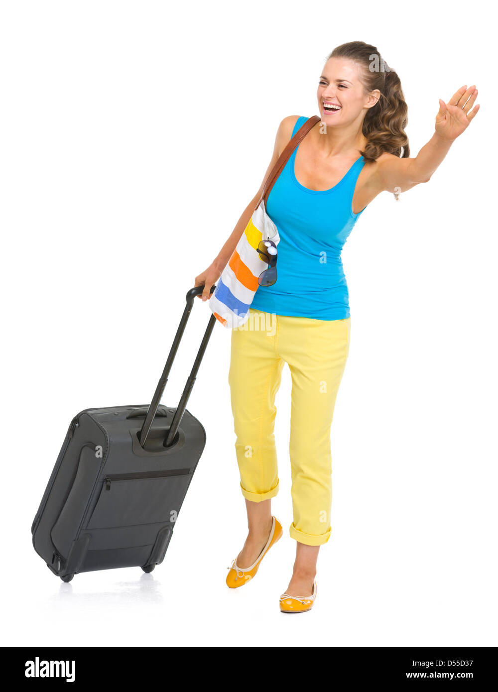 Smiling young tourist woman with wheel bag catching taxi Stock Photo