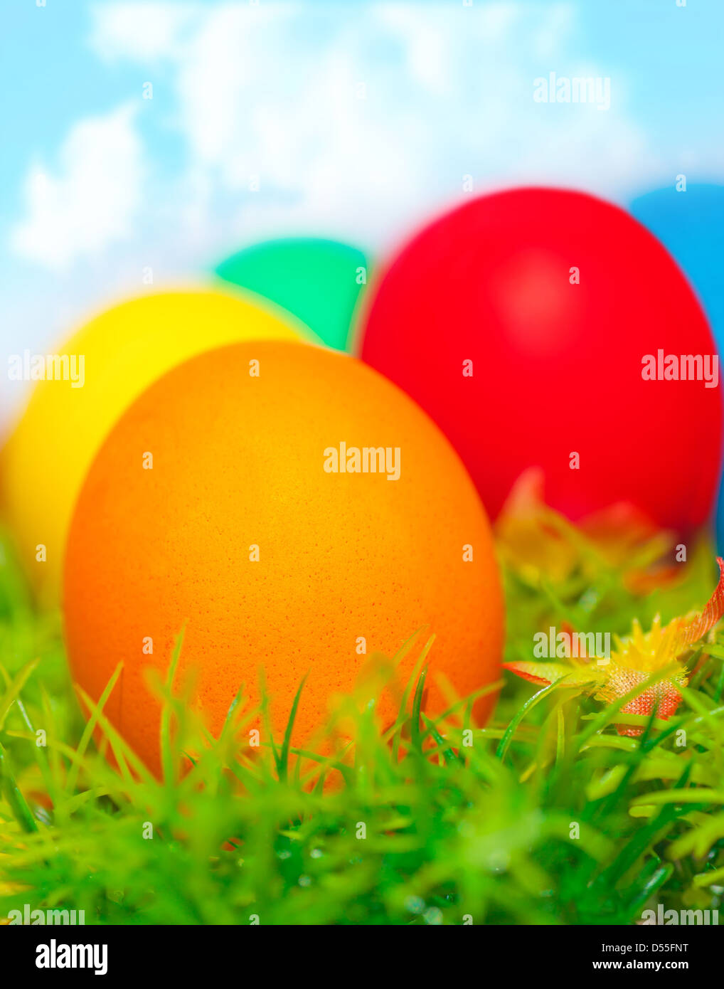 Beautiful painted colorful eggs on fresh green grass over blue sky ...