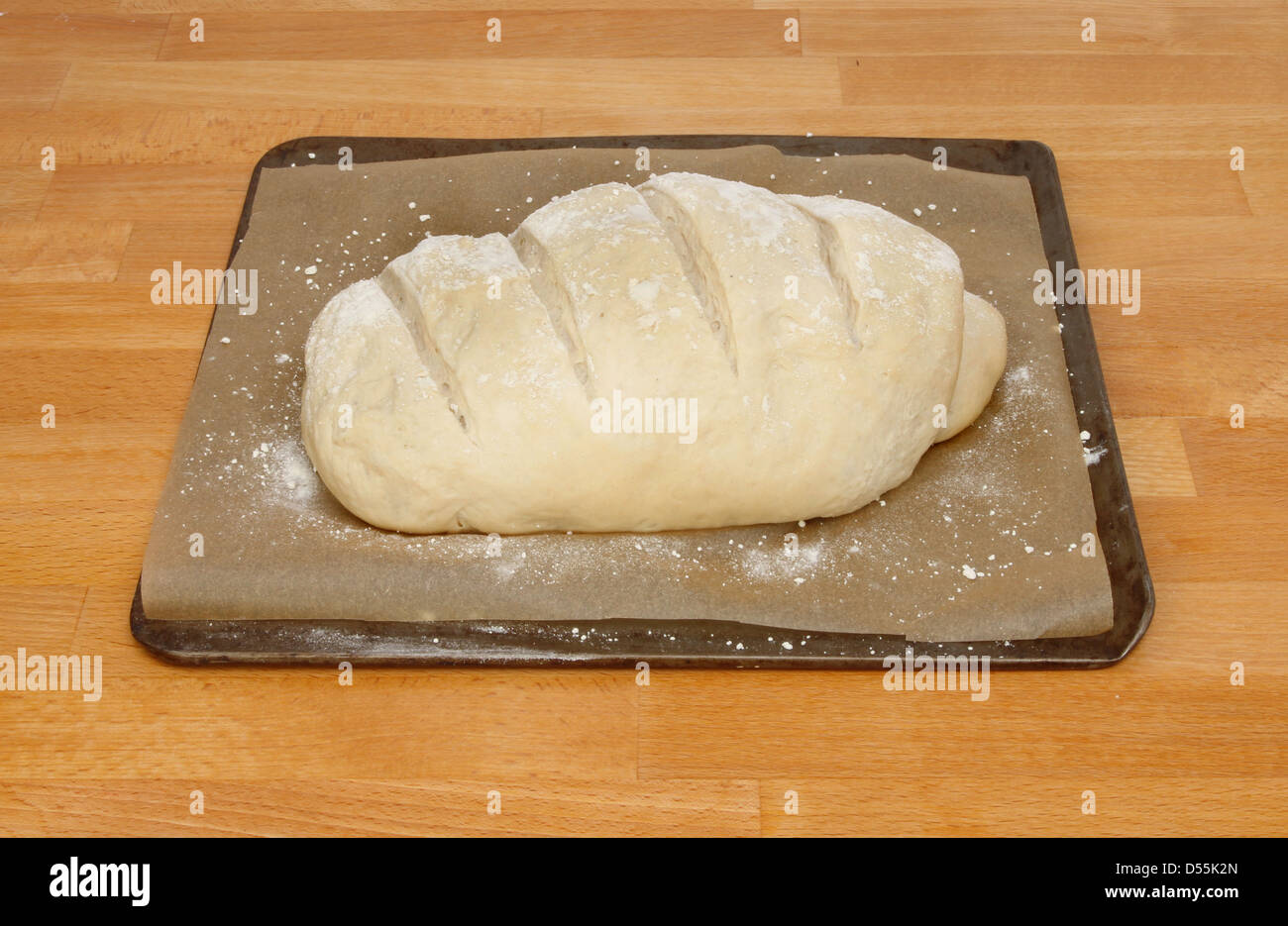 Bread loaf proved and ready for baking on a wooden worktop Stock Photo