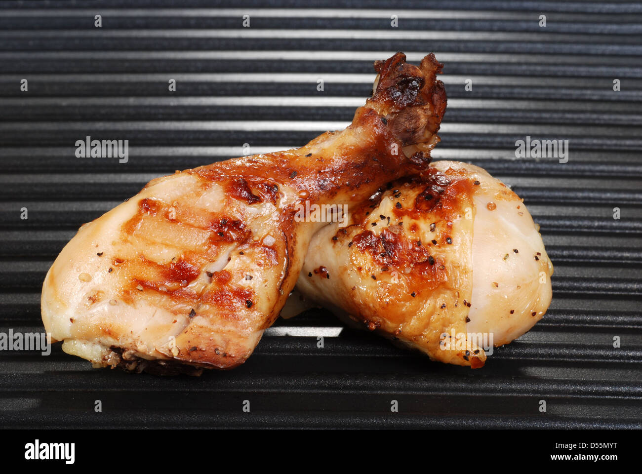two chicken drumsticks on a grill Stock Photo Alamy