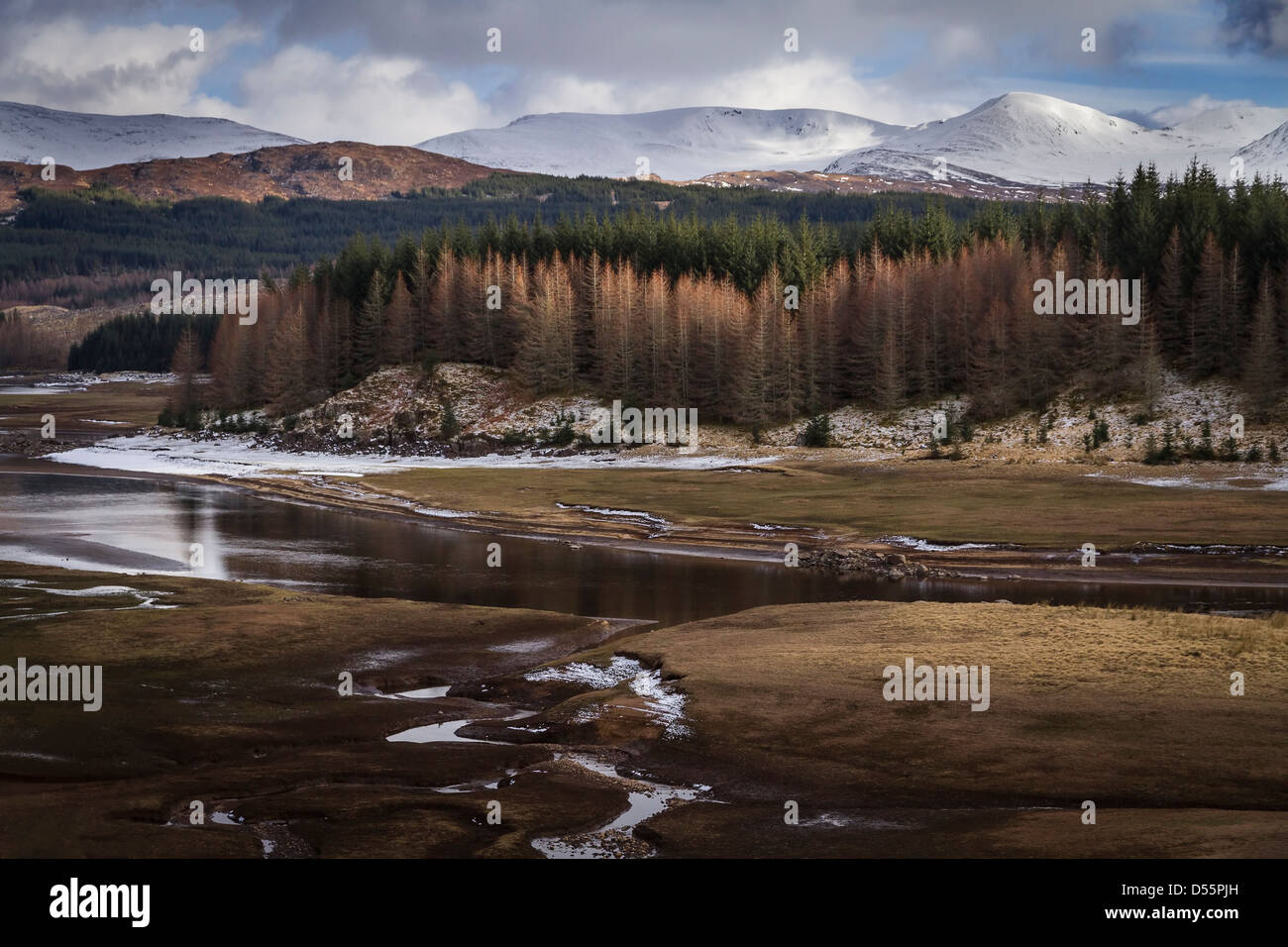 Low water on Loch Laggan with snow covered mountains in the background. Stock Photo