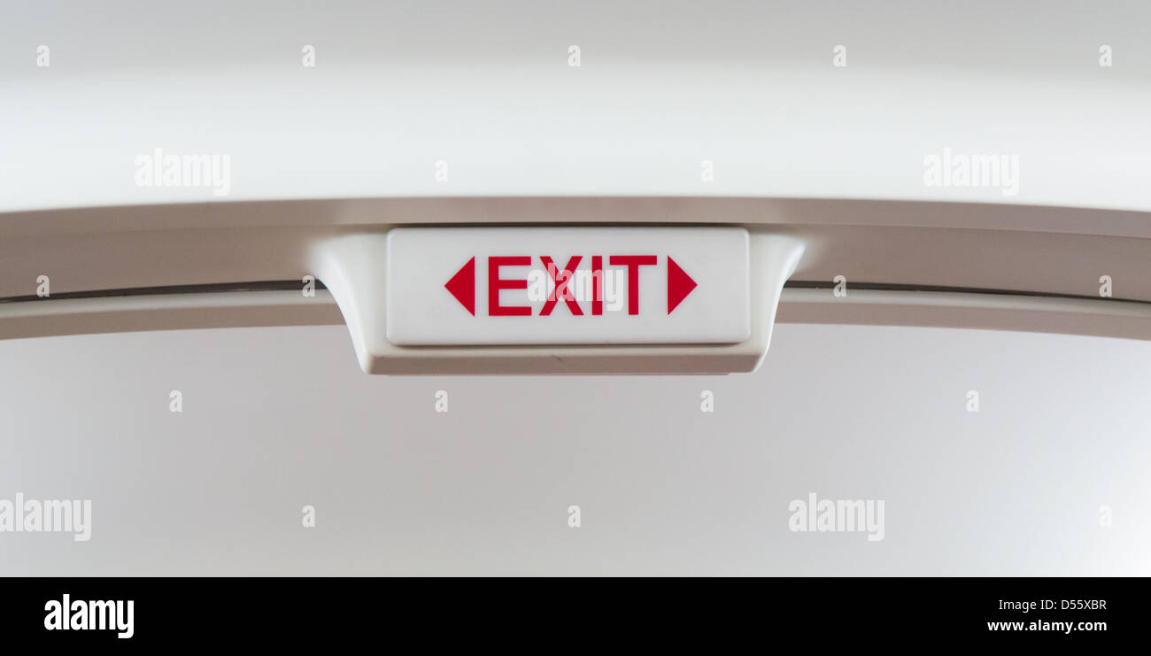 An exit sign on overhead in a typical airliner. Stock Photo