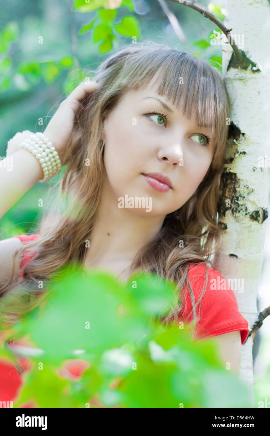 portrait of the young beautiful girl which costs at a birch tree in the ...