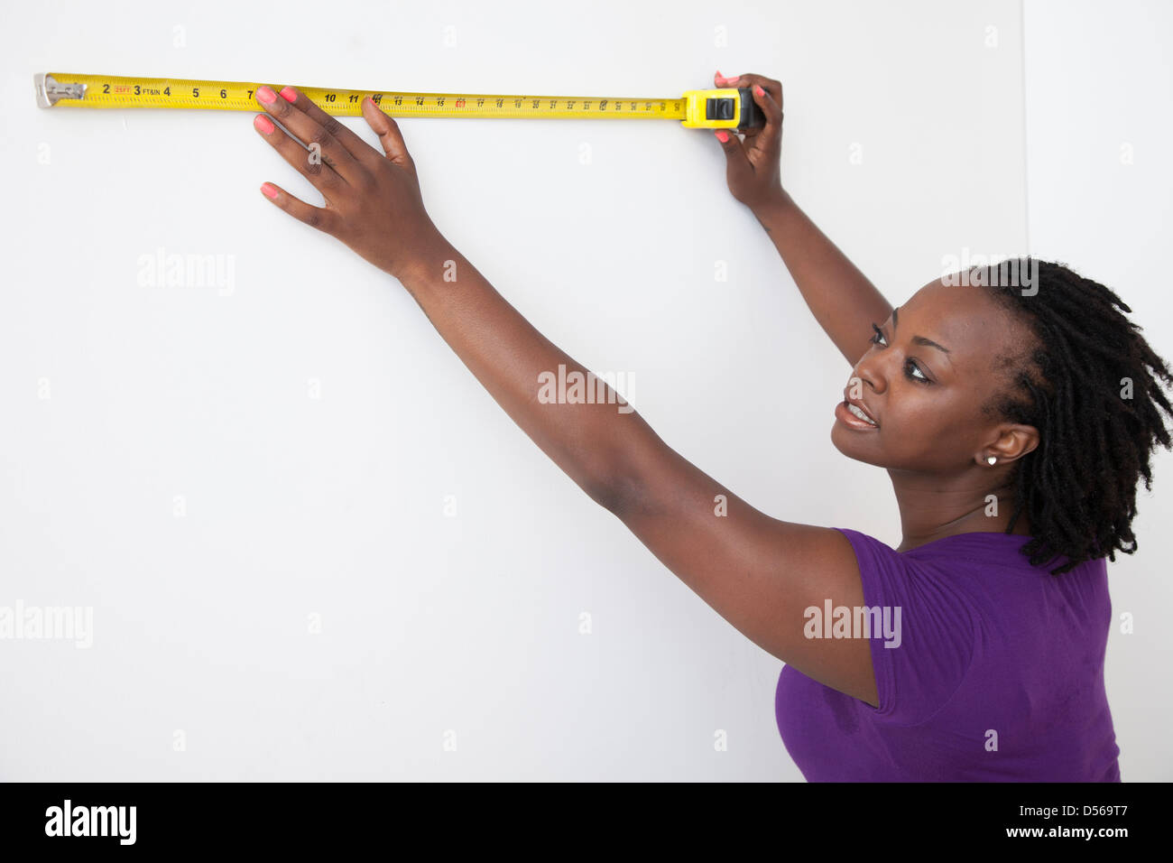 Black woman measuring wall Stock Photo - Alamy