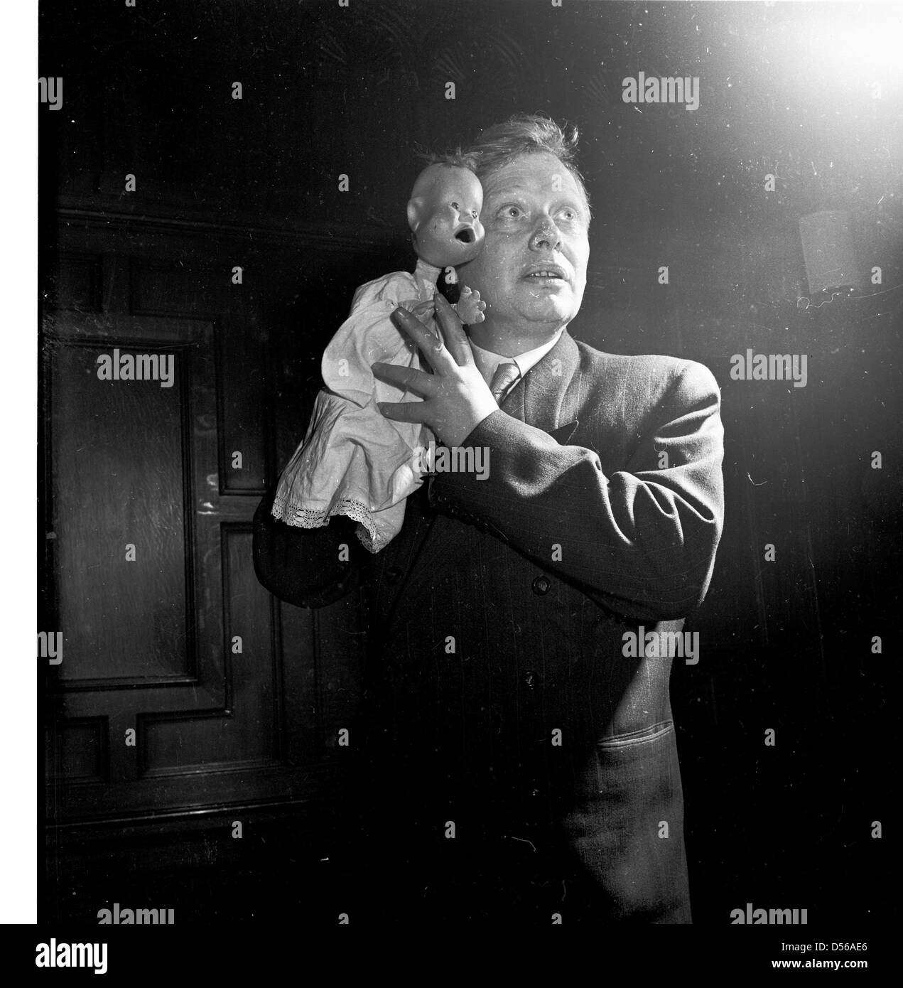 Historical 1950s. England. Ventriloquist performs with his baby dummy