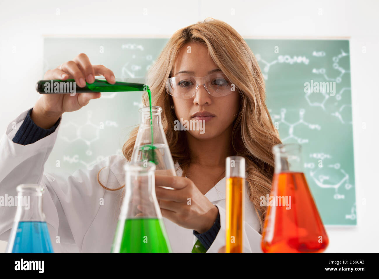 Mixed race student working in chemistry lab Stock Photo