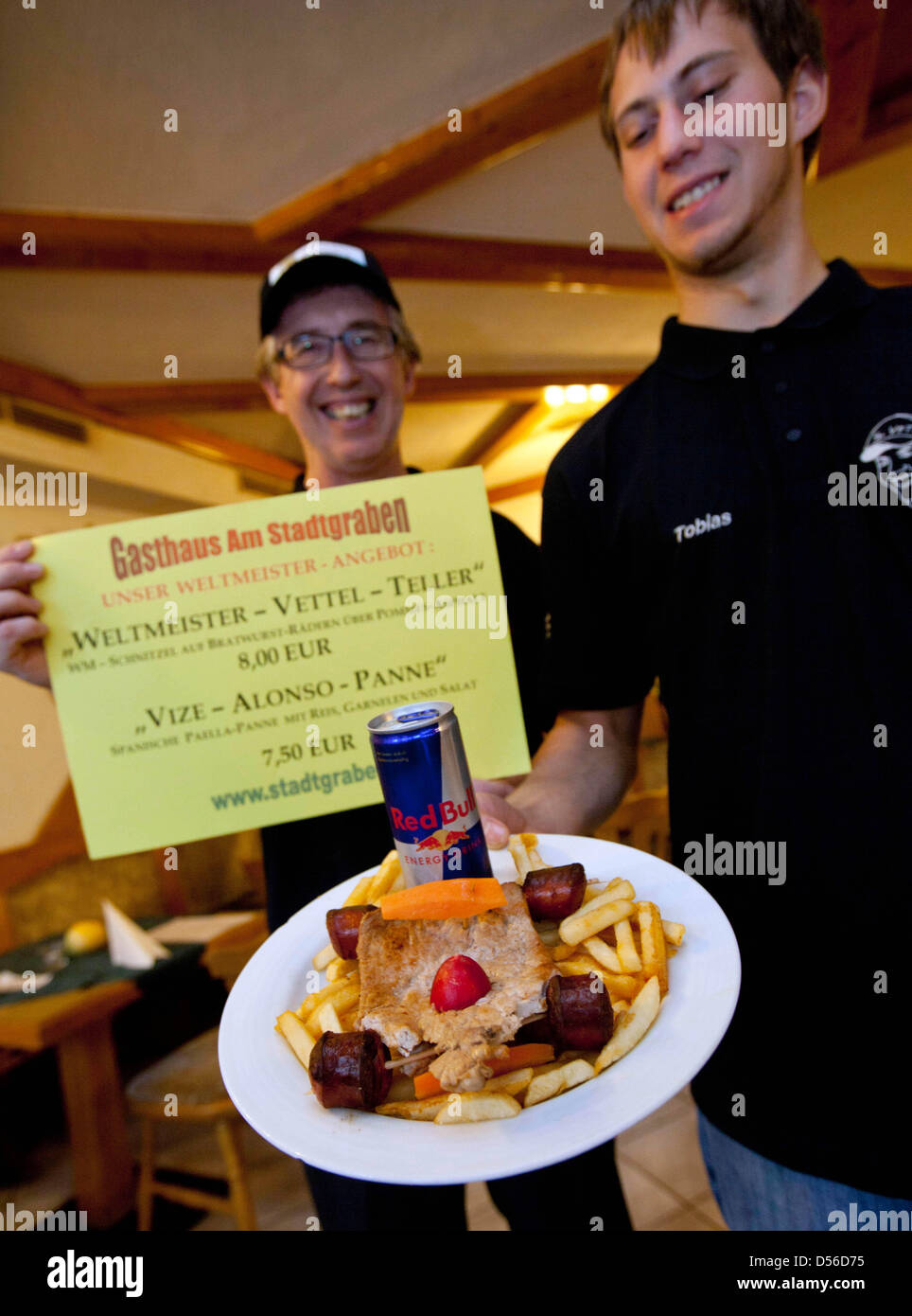 Restaurant owner Adi Doersen (L) and his son Tobias (R) present the 'World Champion Vettel dish' dedicated to the 2010 Formula One World Champion, Germany's Sebastian Vettel of Red Bull Racing, in Heppenheim, Germany, 15 November 2010. Winning the Formula 1 Abu Dhabi Grand Prix, Germany's Sebastian Vettel of Red Bull Racing clinched the title and becomes the youngest-ever world cha Stock Photo