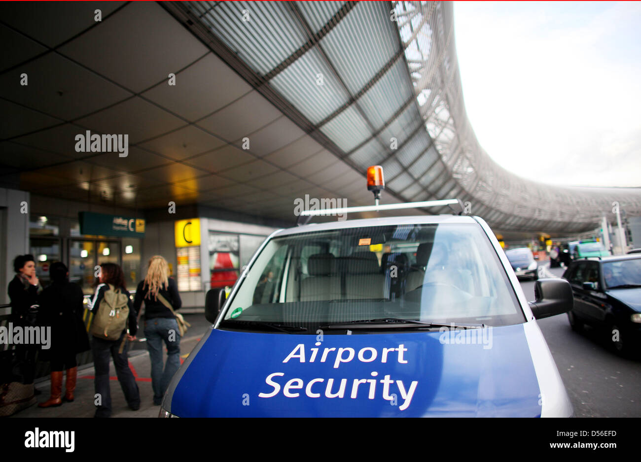 An Airport Security vehicle is parked outside the terminal at the