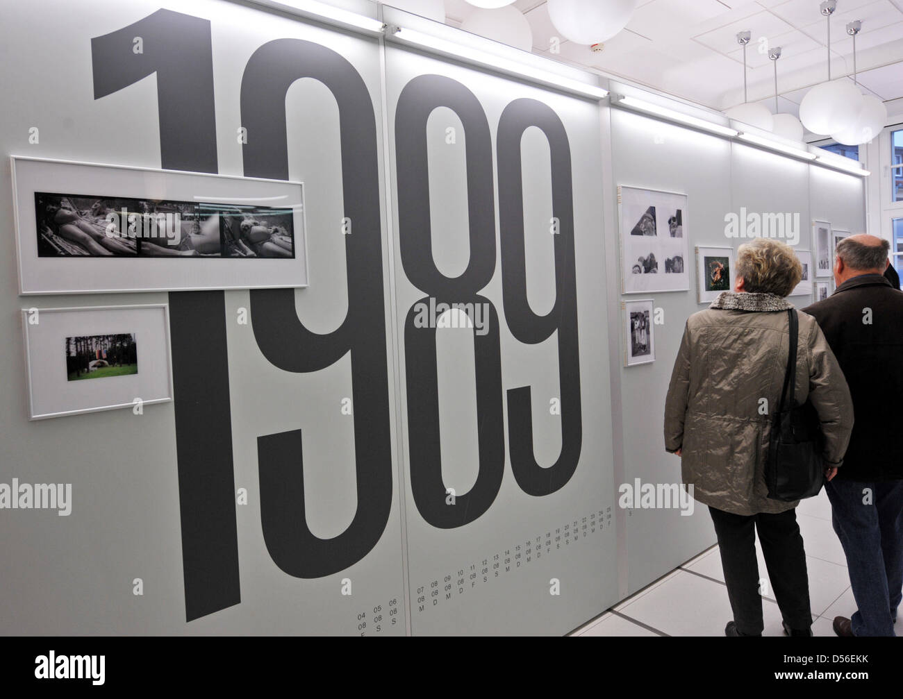 Visitors examine historical photographs at an exhibition on the German Reunification on the day that Lothar de Maiziere, the first freely elected GDR President, will be made honorary citizen at city hall in Nordhausen, Germany, 17 November 2010. de Maiziere's native Nordhausen makes him an honorary citizen for his efforts at German renification. Photo: Martin Schutt Stock Photo