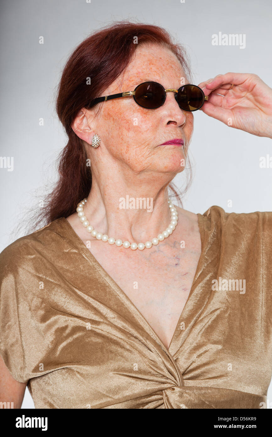 Portrait of good looking senior woman wearing sunglasses with ...