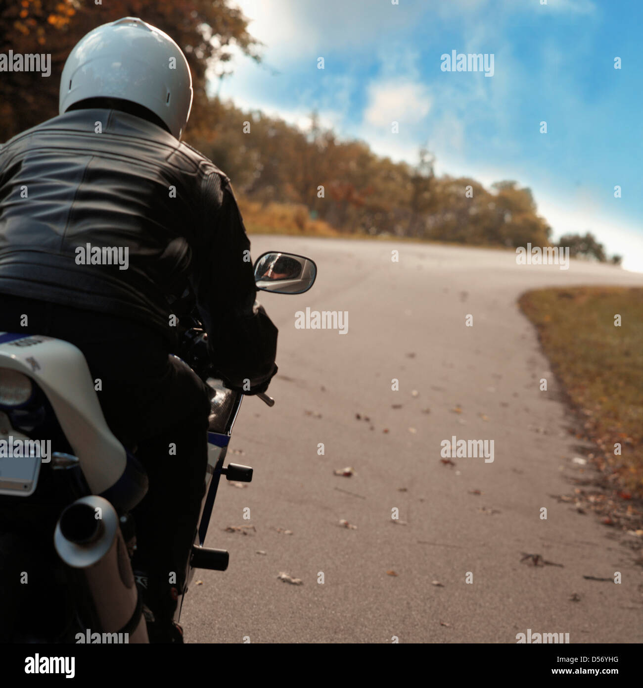 Man riding motorcycle on rural road Stock Photo