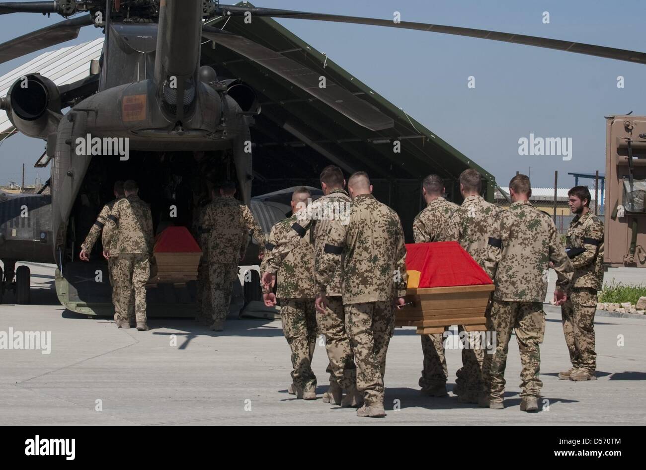 Bundeswehrsoldaten verladen am Ostersonntag (04.04.2010) im Feldlager des Wiederaufbauteams Kundus die Särge von drei gefallenen Kameraden in einen Helikopter. Zwei Tage nach den blutigen Gefechten von Kundus haben die Bundeswehrsoldaten dort Abschied von ihren drei getöteten Kameraden genommen. Noch am Sonntag sollen die Särge mit Hubschraubern und einem Militärflugzeug zunächst ü Stock Photo