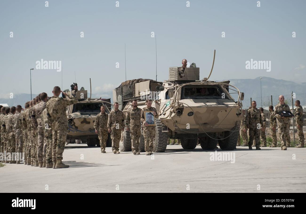 Bundeswehrsoldaten salutieren am Ostersonntag (04.04.2010) im Feldlager des Wiederaufbauteams Kundus ihren drei gefallenen Kameraden. Zwei Tage nach den blutigen Gefechten von Kundus haben die Bundeswehrsoldaten dort Abschied von ihren drei getöteten Kameraden genommen. Noch am Sonntag sollen die Särge mit Hubschraubern und einem Militärflugzeug zunächst über Masar-i-Sharif in das  Stock Photo