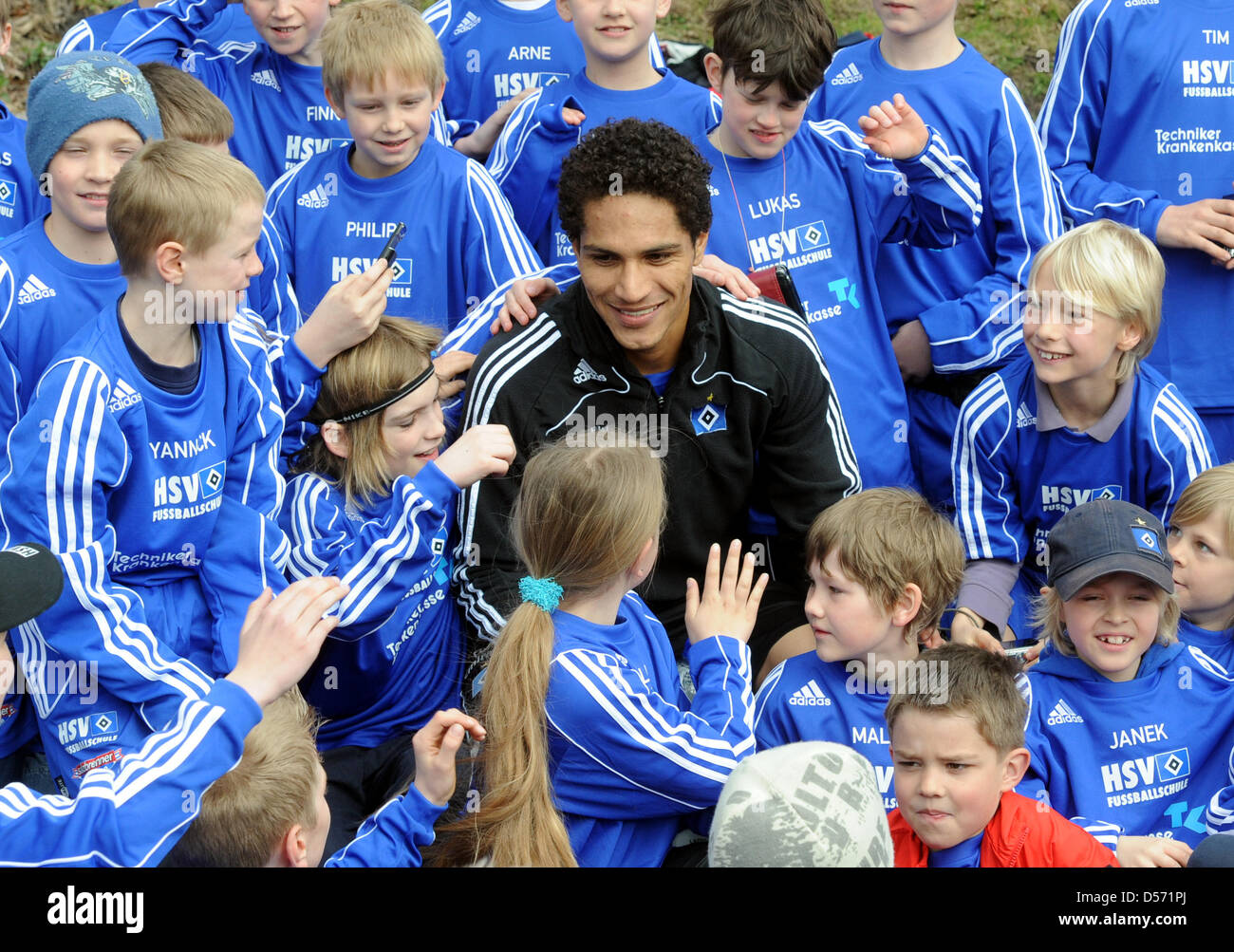 Hamburg's José Paolo Guerrero (C) poses for a photo with children of the HSV soccer school after a training session of German Bundesliga soccer club SV Hamburg in Hamburg, Germany, 06 April 2010. After the goalless draw in the Bundesliga match against Hanover 96 on 04 April 2010, Guerrero threw a drinking bottle in a fan's face who had provoked him before. Guerrero could be suspend Stock Photo