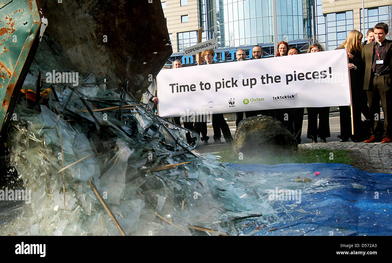 Delegates of the UN Climate Change Talks pass a symbolic pile of broken glass in Bonn, Germany, 09 April 2010. Environmental activists called on the delegates to act after the failing of UN Climate Conference in Copenhagen. In a symbolic action they mounted four tons of borken glass and added a banner reading 'Time to pick the pieces!' The three-day Bonn Climate Change Talks aim to Stock Photo