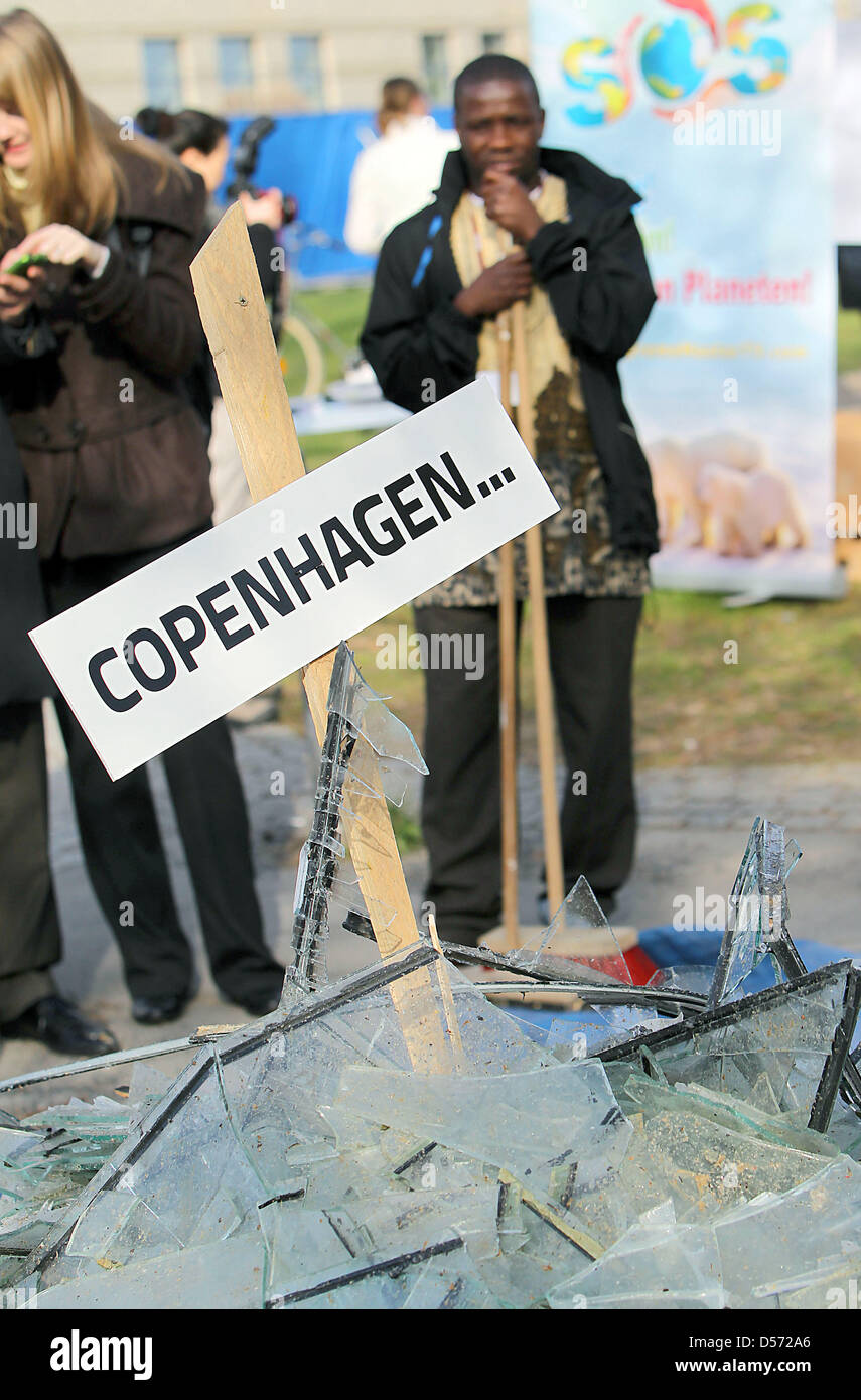 Delegates of the UN Climate Change Talks pass a symbolic pile of broken glass in Bonn, Germany, 09 April 2010. Environmental activists called on the delegates to act after the failing of UN Climate Conference in Copenhagen. In a symbolic action they mounted four tons of borken glass and added a banner reading 'Time to pick the pieces!' The three-day Bonn Climate Change Talks aim to Stock Photo