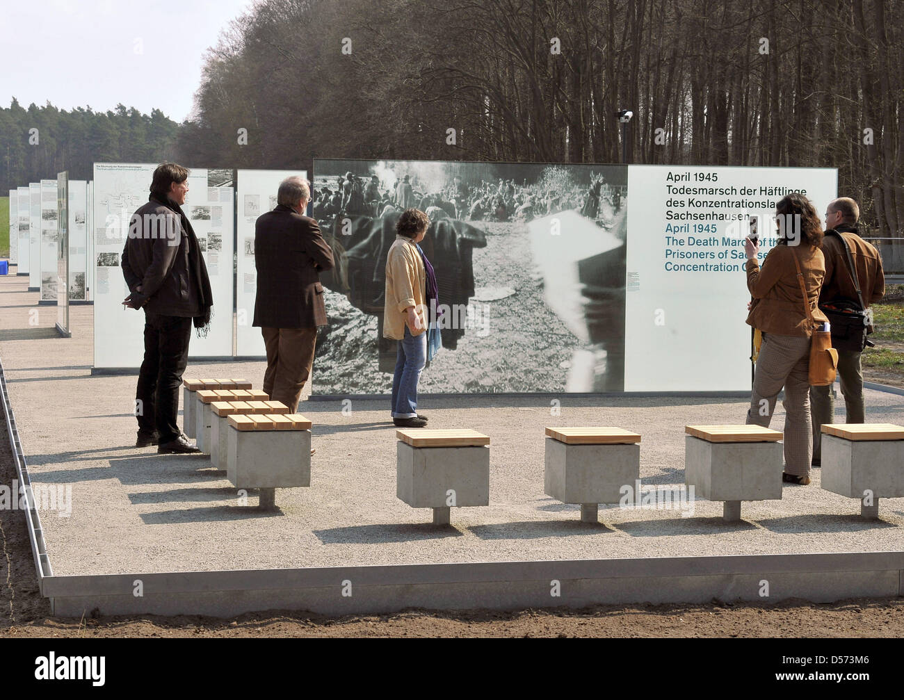 Journalists take a look at the new information boards of the memorial site for the death march of prisoners of the concentration camp Sachsenhausen in the Below Forest near Wittstock, Germany, 14 April 2010. The memorial site will be reopened on 16 April 2010 after nine months of rearrangement. Glass boards, prisoners' drawings and quotes, documents and photos illustrate the suffer Stock Photo