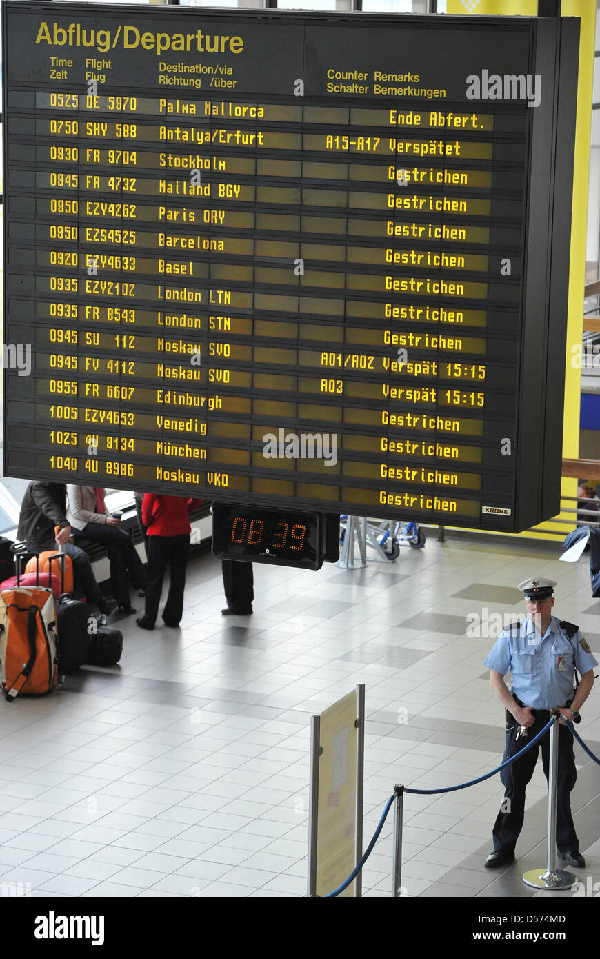 A customs officer stands under an information board displaying cancelled  flight at Schoenefeld airport in Berlin, Germany, 16 April 2010. Due to the  ashes of the volcanic eruption in Iceland, air traffic