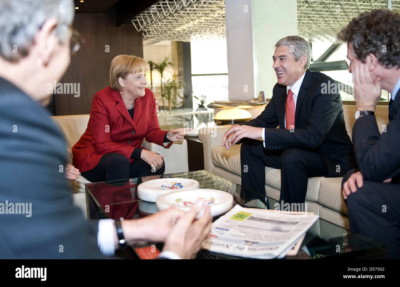 German Chancellor Angela Merkel (2-L) chats with Portugal's Prime Minister Jose Socrates (2-R) at the airport in Lisbon, Portugal, 16 April 2010. Merkel's plane was forced to stop over in Lisbon due to clouds of volcanic ashes thrown out by Icelandic volcano Eyfjalla. Mrs Merkel was on her way back to Germany following her visit to the USA. She will not be able to continue to Germa Stock Photo