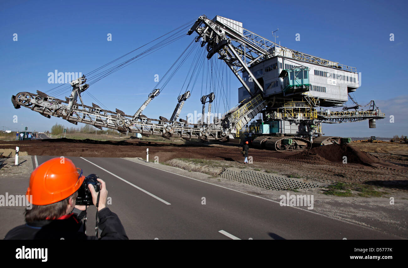 A 960-ton-heavy bucket-chain dredger crosses a street between Profen and Hohenmoelsen, Germany, 22 April 2010. The dredger is on the way to the brown coal district Schwerzau of the Profen surface mine. The dredger is 22 metres high and mines 1000 cubic metres of brown coal and waste material per hour. Photo: JAN WOITAS Stock Photo