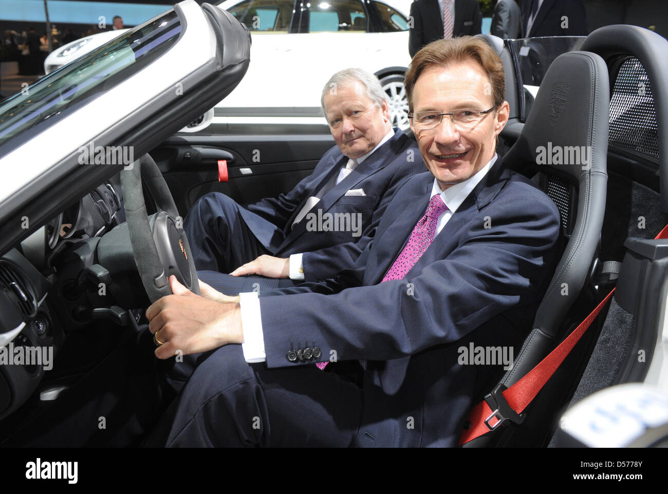 Michael Macht (R), CEO of Porsche AG, and Wolfgang Porsche, chairman of the Porsche supervisory board, sit in a Porsche Boxter Spyder prior to the general meeting of Volkswagen AG in Hamburg, Germany, 22 April 2010. Europe's largest automaker Volkswagen increased its profits in the first quarter of 2010. The earnings after taxes increased by nearly 95 per cent to 473 million euros, Stock Photo