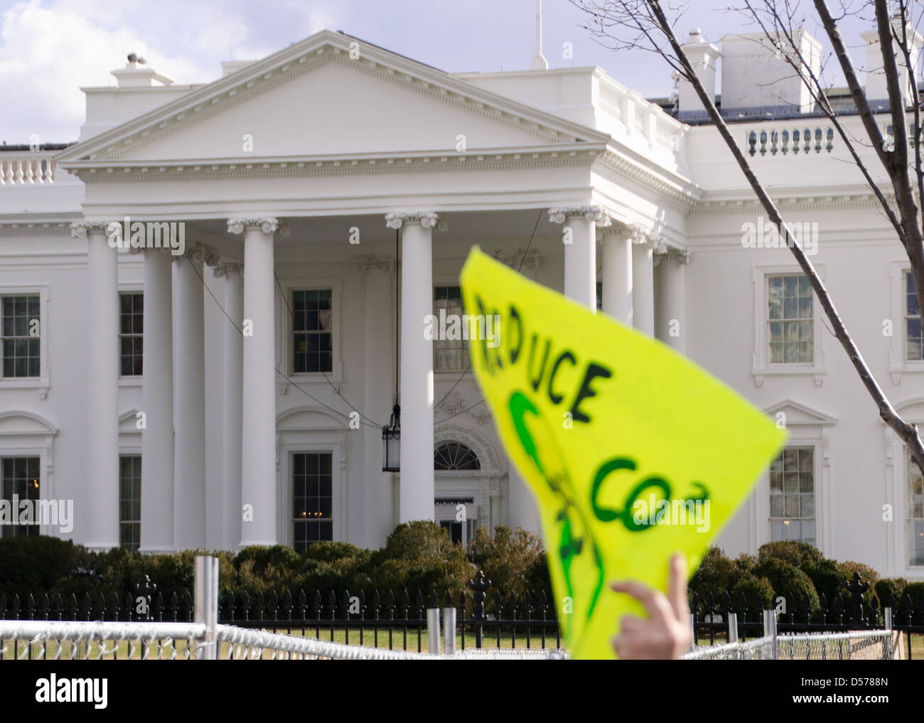 An environmental protester waves their sign outside the White House during a protest in Washington DC USA Stock Photo
