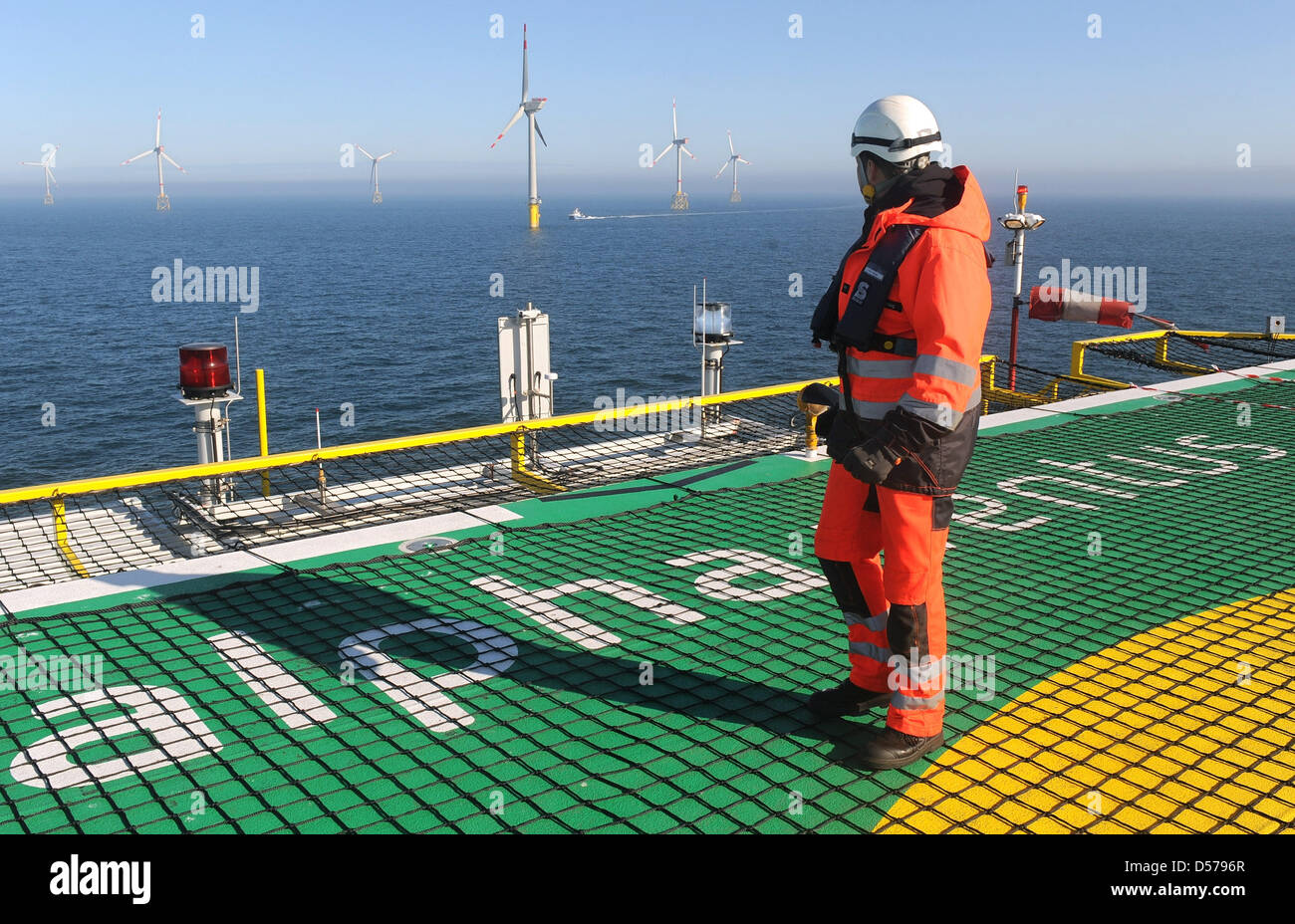 Shortly before the official induction of the first German Offshore-Windpark ''Alpha Ventus'', an employee walks over the helicopter platform in the North Sea near Borkum, Germany, 27 April 2010. The test field consisting out of twelve wind turbines stands around 45 kilometers in front of the East Frisian island Borkum and can supply around 50,000 homes with electricity. Alpha Ventu Stock Photo