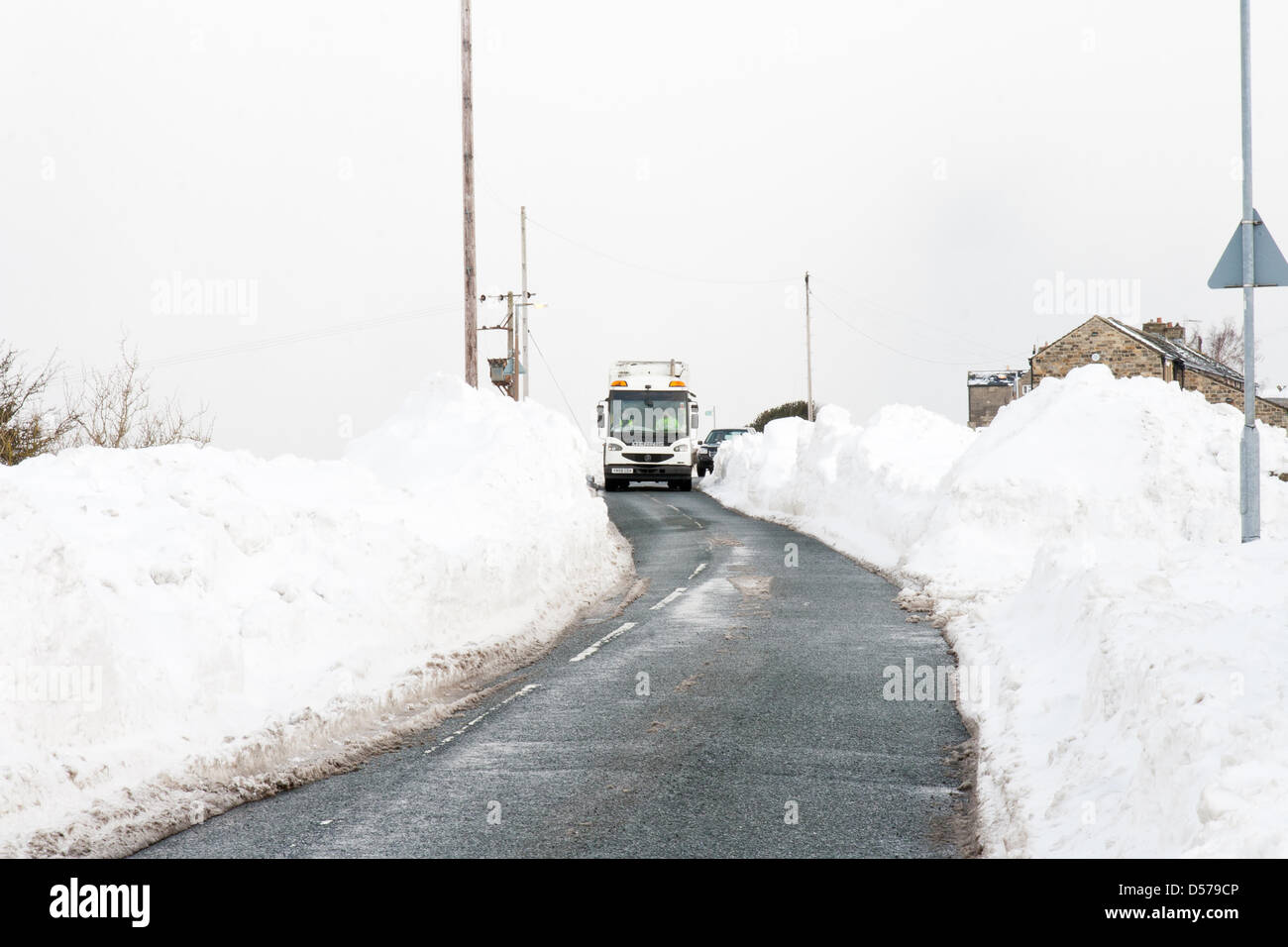 A bin lorry making its way along Ashes Lane, near Almondbury, West Yorkshire, England in the snow. Stock Photo
