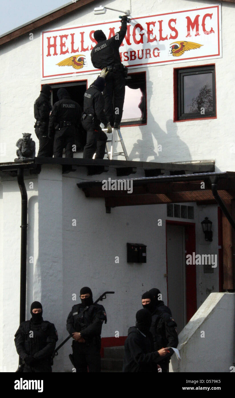 Hooded policemen unscrew the club sign of the motorbike club 'Hells Angels'  in Flensburg, Germany, 29 April 2010. The two motorbike clubs 'Hells Angels  MC Charter Flensburg' and 'Bandidos MC Probationary Chapter