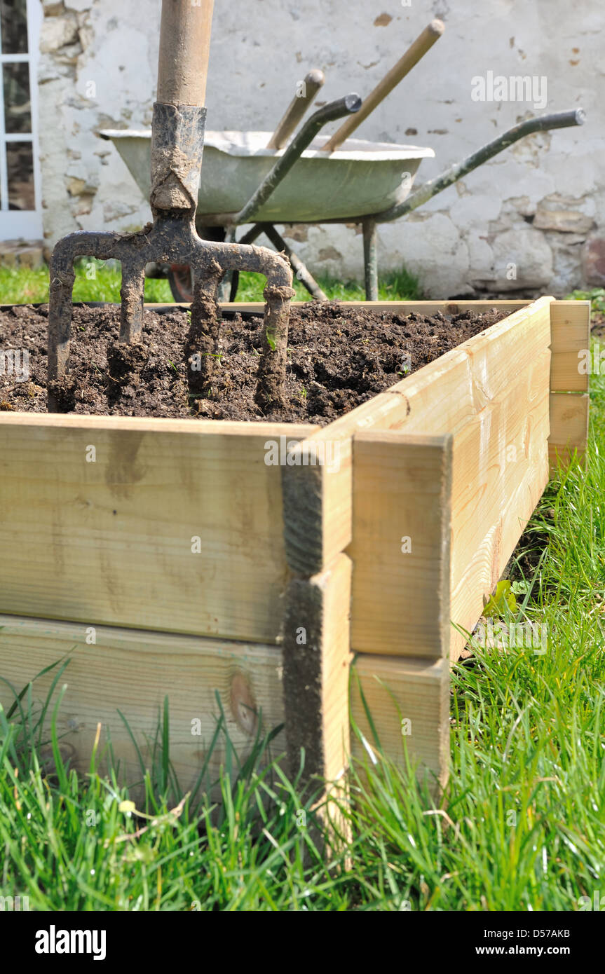 spade in a wooden planter for vegetable garden Stock Photo Alamy