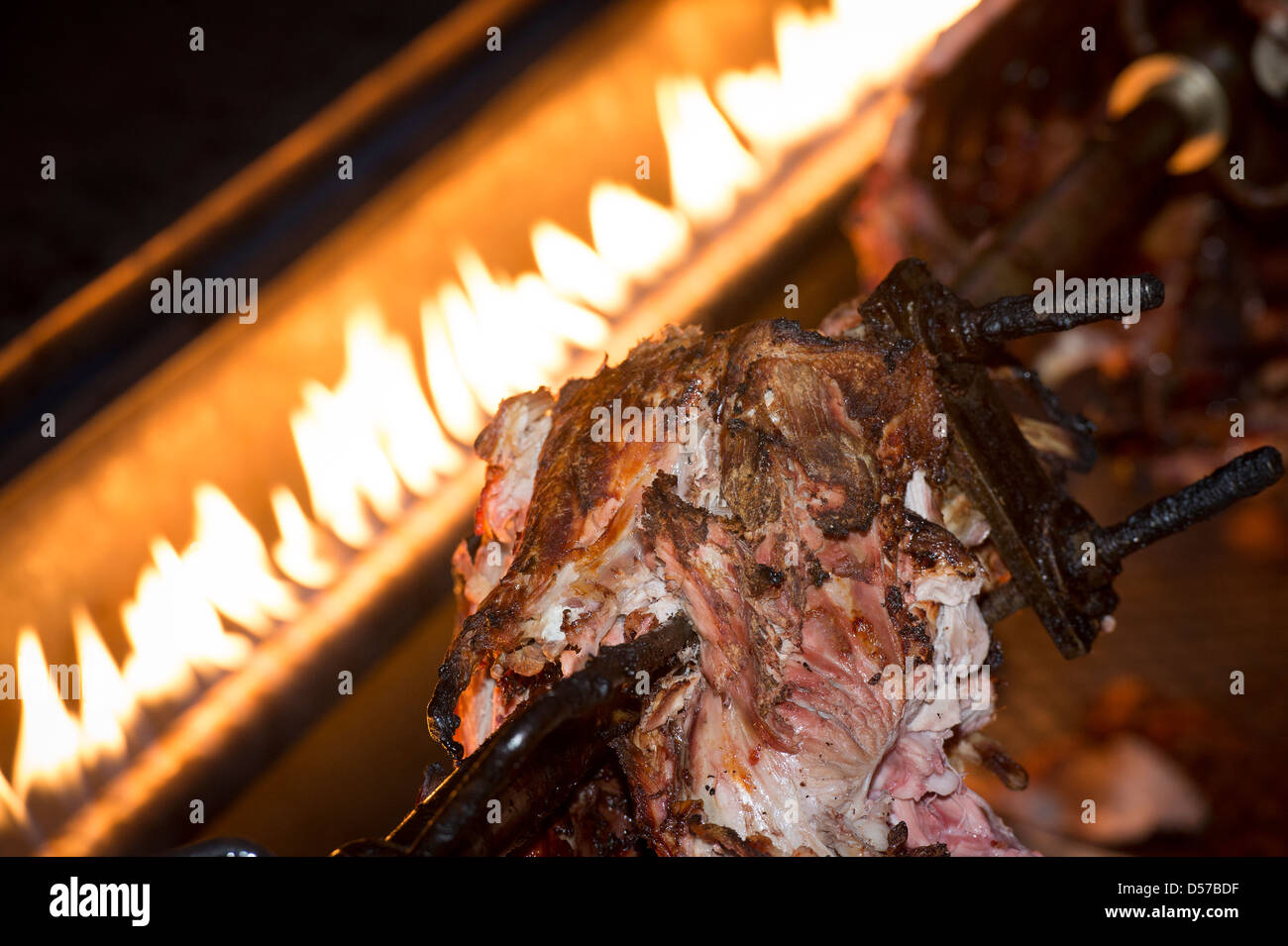 Remains of a hog roast being cooked on a spit. Stock Photo