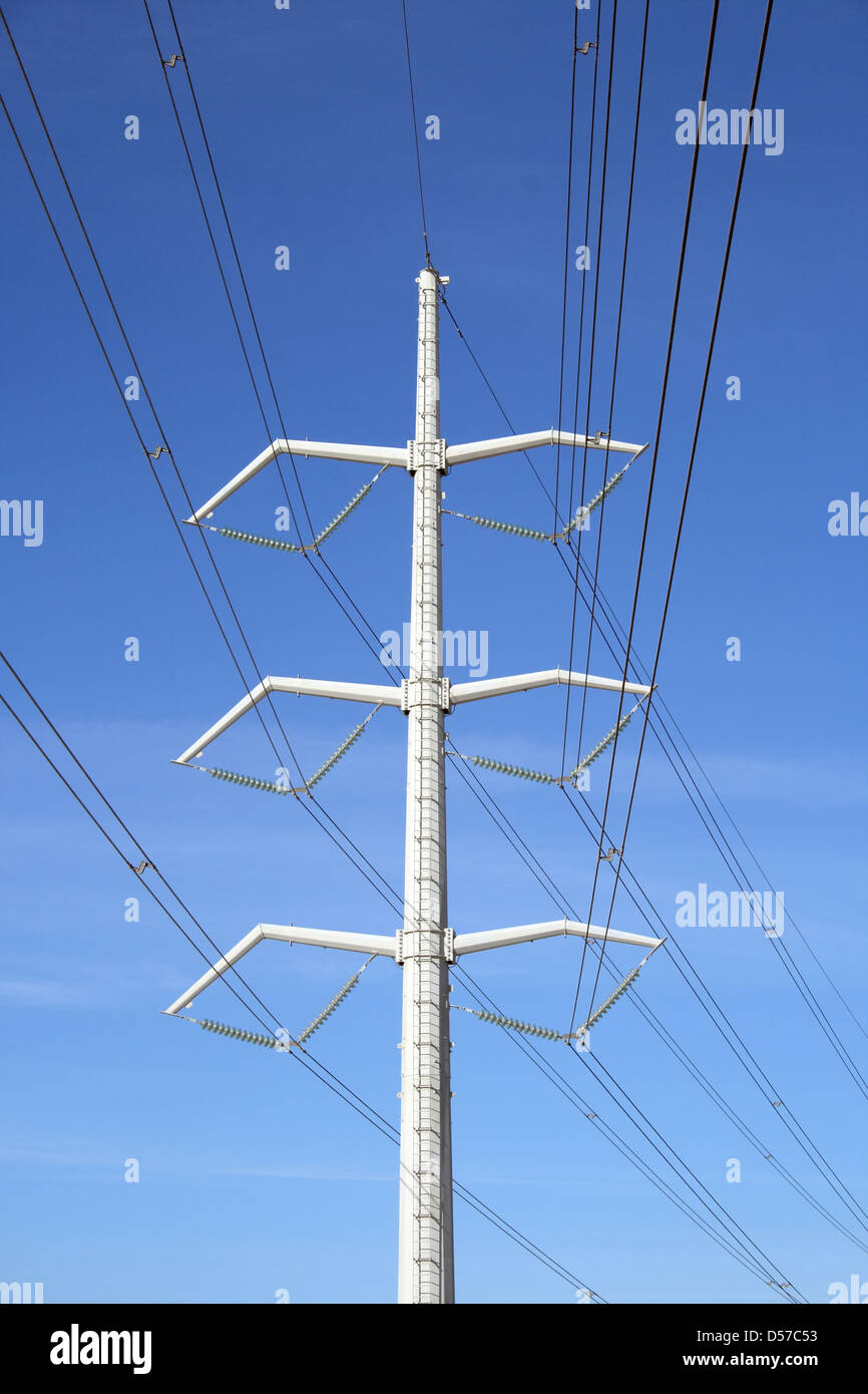 White high voltage electricity pylon and power lines against the blue ...