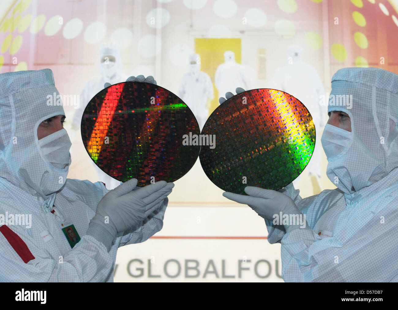 Staff members of chip producer Globalfoundries present wafers during a press conference in Dresden, Germany, 20 January 2010. For developers and users of computer chips, only a faster process was significant. The question of how much energy the devices used or wasted was of no interest in the race for performance speed. Nowadays, energy effiiency has become a major sales argument.  Stock Photo