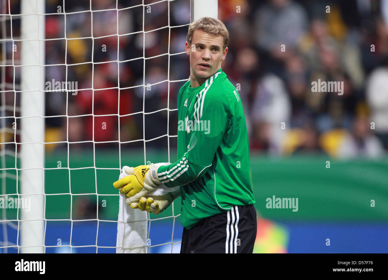 Germany's goalie Manuel Neuer cleans his gloves during the charity
