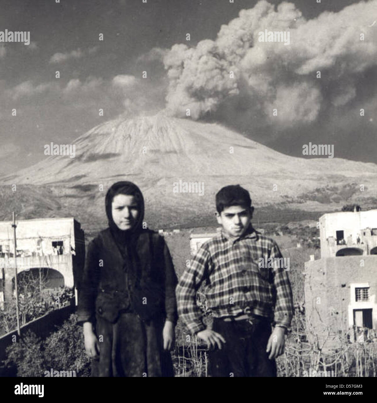 This photograph shows children near their homes during the 1944 eruption of Mount Vesuvius, Italy. The eruption caused widespread devastation, and many homes were covered in ash and debris. Stock Photo