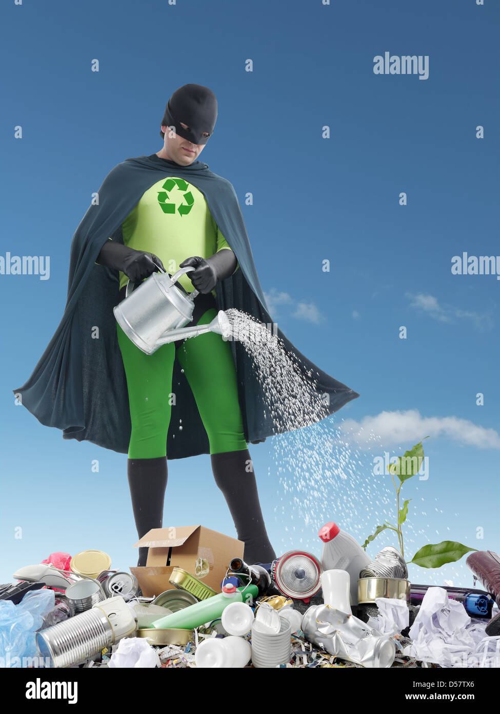 Eco superhero watering green plantlet growing on dumpyard - green  environment concept Stock Photo - Alamy