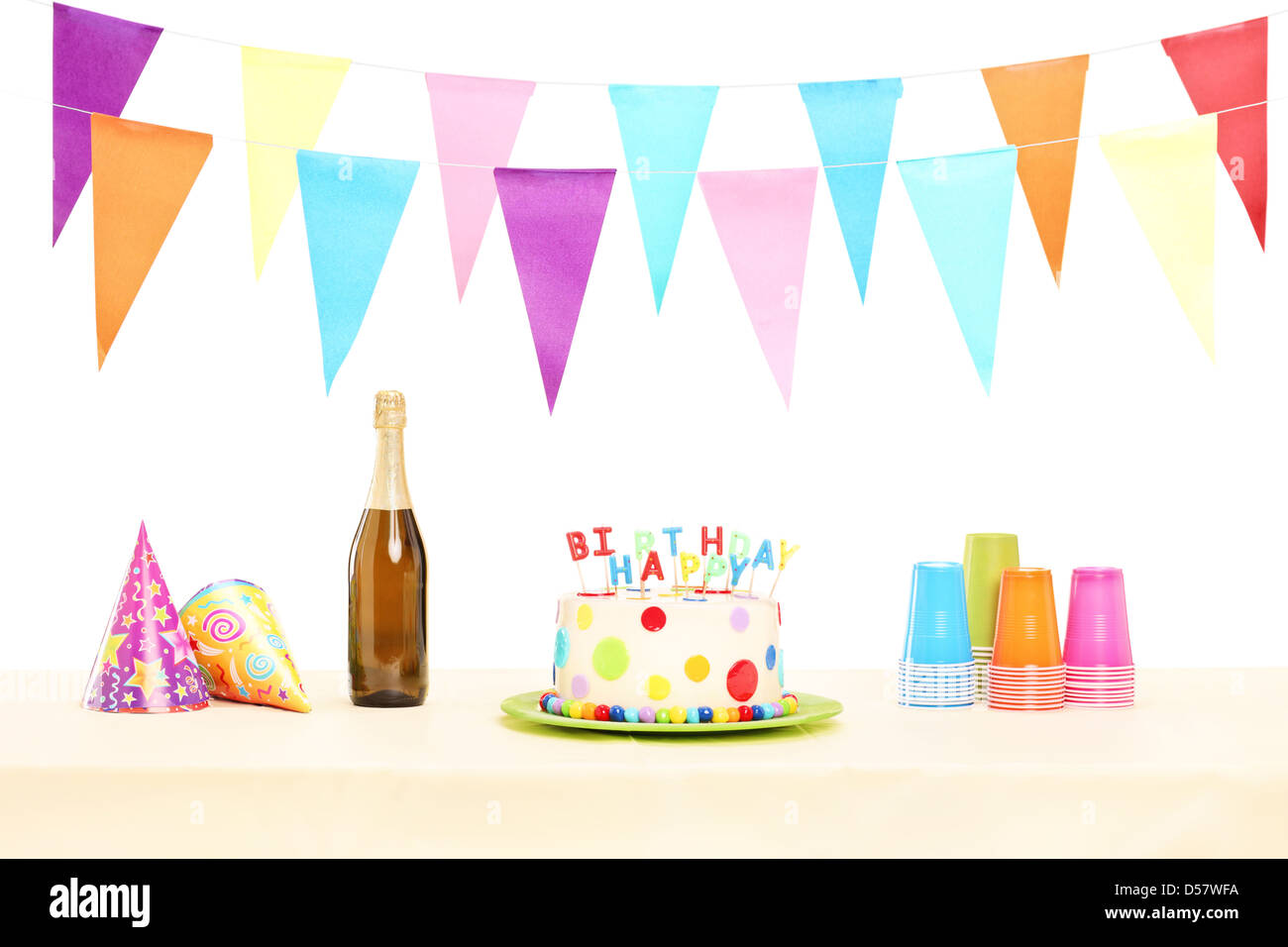 Bottle of sparkling wine, plastic glasses, party hats and birthday cake isolated on white background Stock Photo