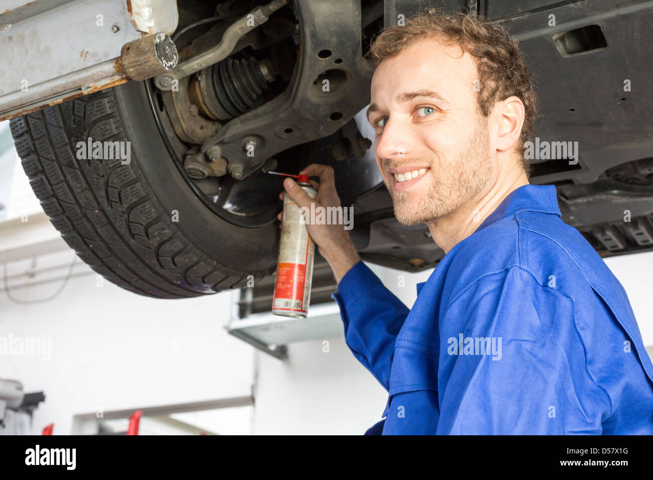 Car mechanics repairing a car on hydraulic lift Stock Photo Alamy