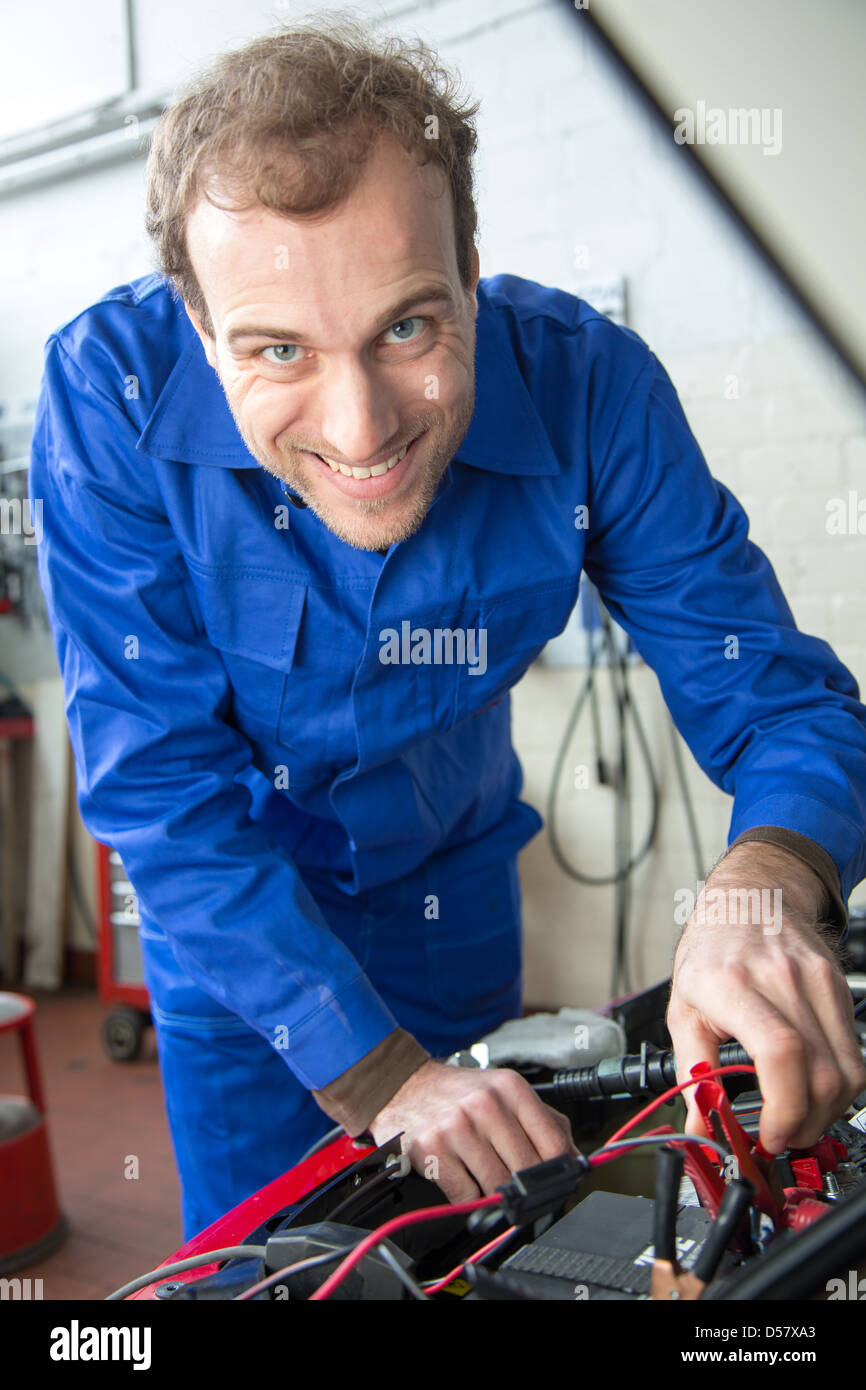 Car mechanic repairing a automobile in a garage or Stock Photo