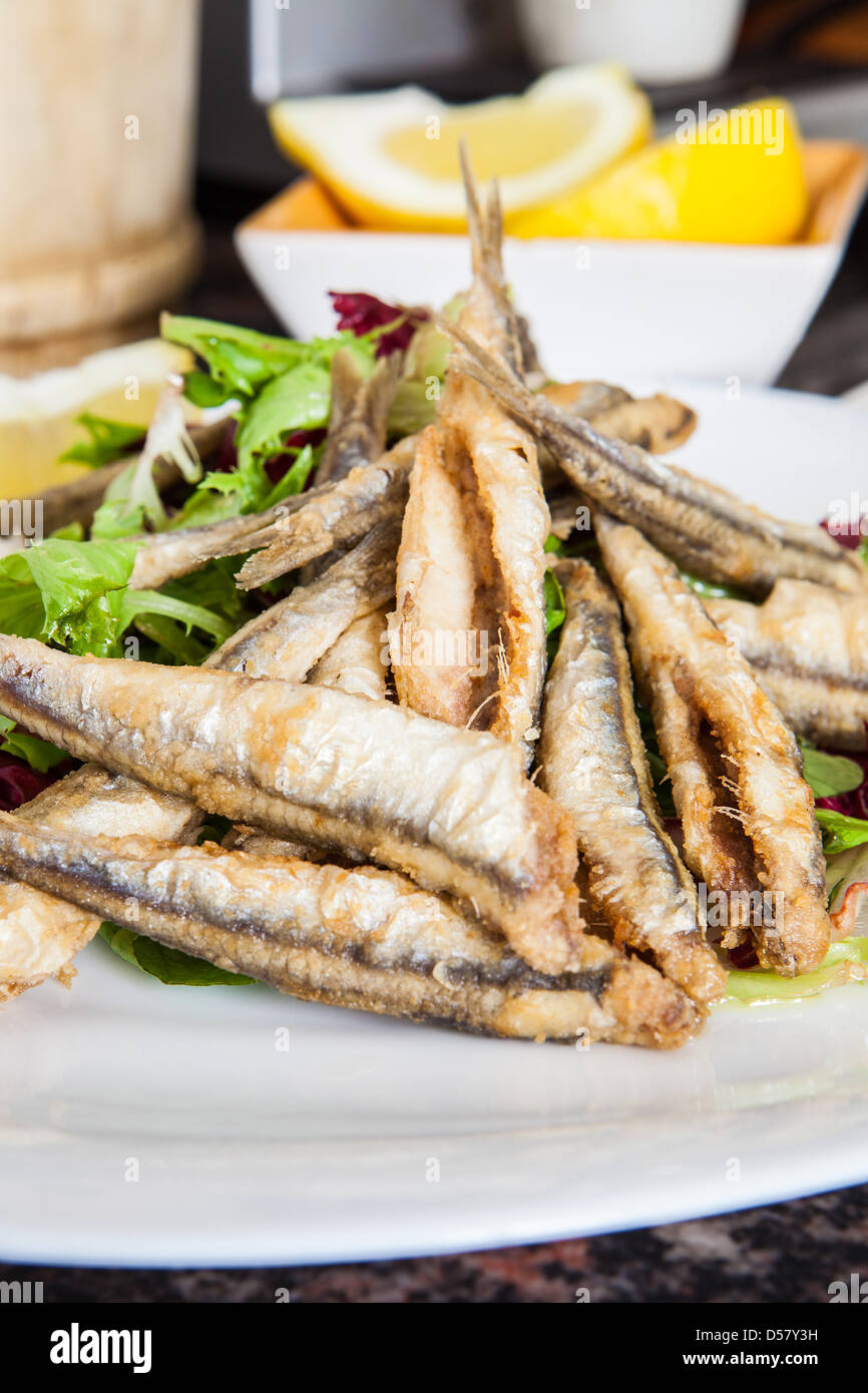 a plate of deep fried anchovies with lemon and salad Stock Photo - Alamy