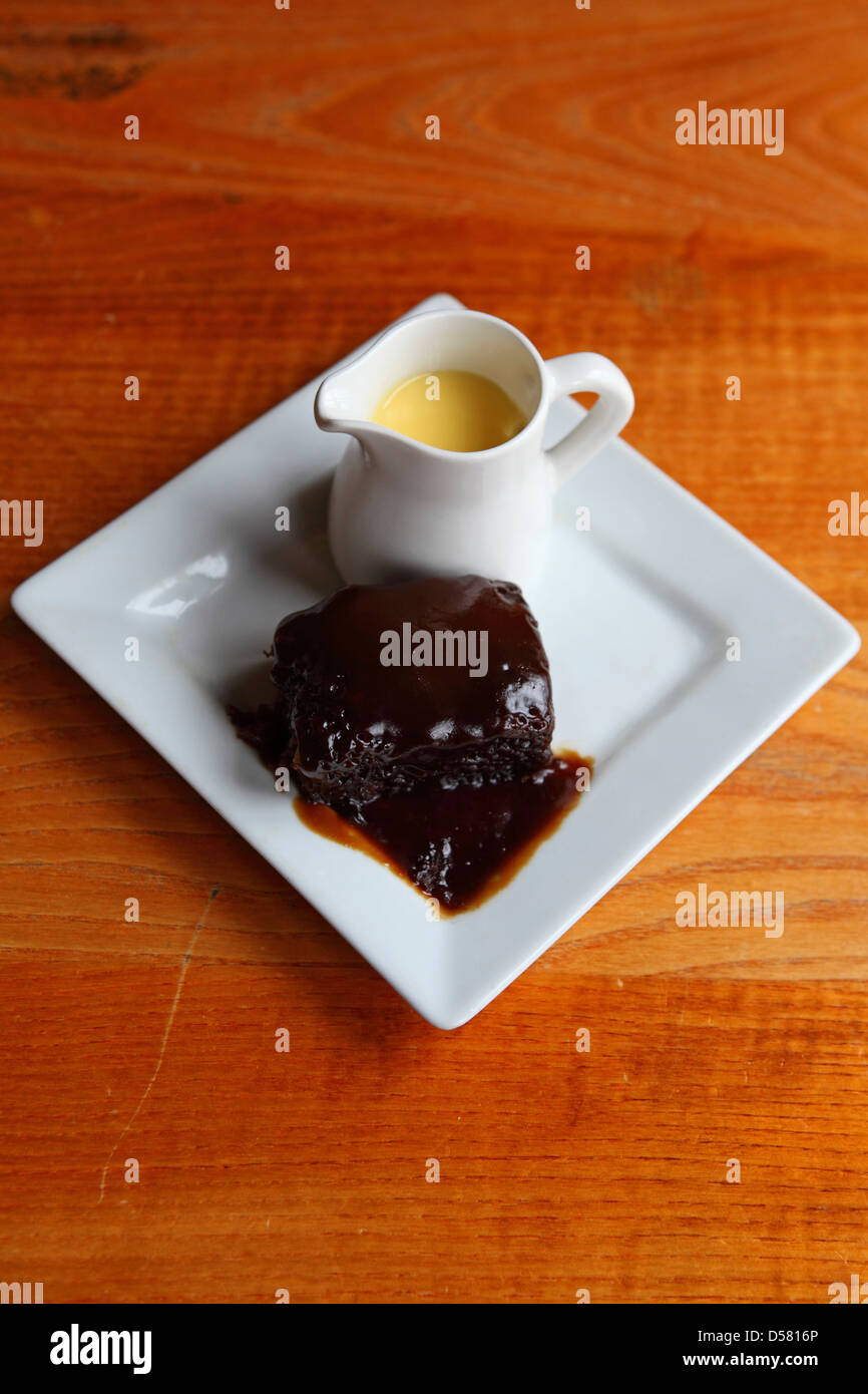 Sticky toffee pudding with a jug of custard Stock Photo Alamy