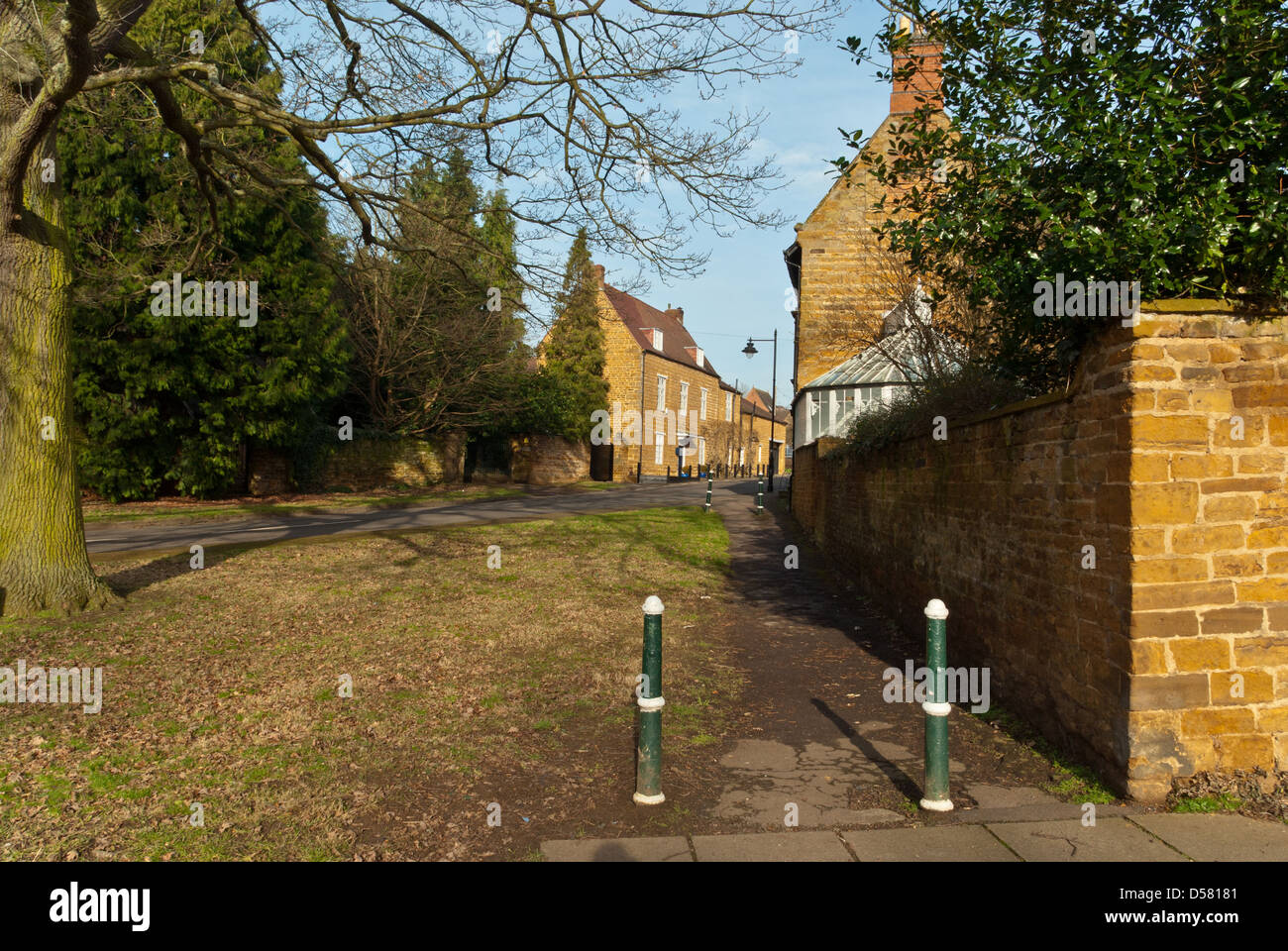 A pathway in the village of Dallington, flanked with buildings of traditional, mellow Northamptonshire stone Stock Photo