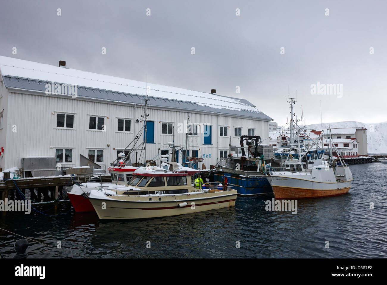 old warehouses and small fishing boats Honningsvag harbour finnmark norway europe Stock Photo
