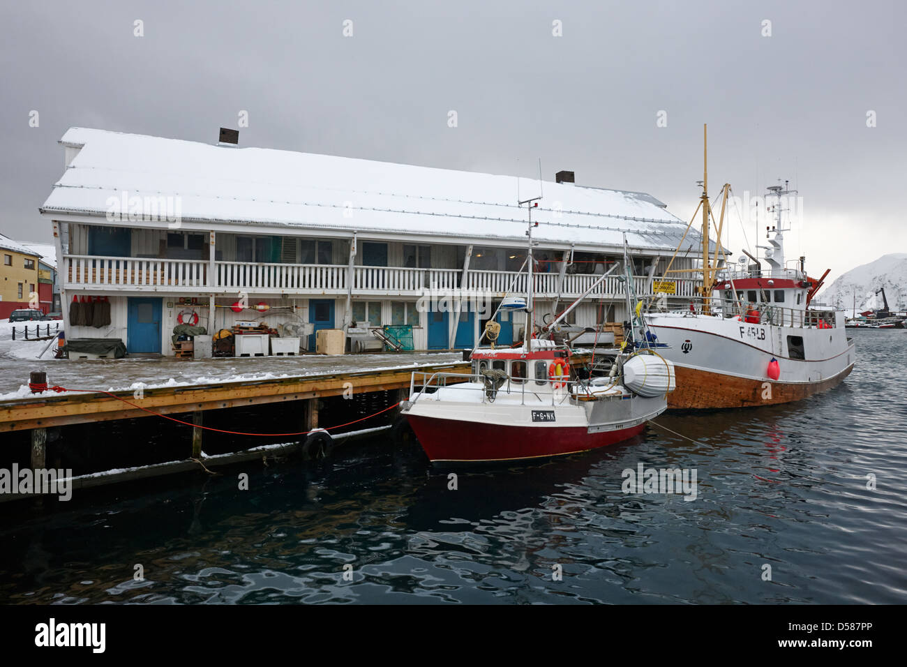 old warehouses and small fishing boats Honningsvag harbour finnmark norway europe Stock Photo
