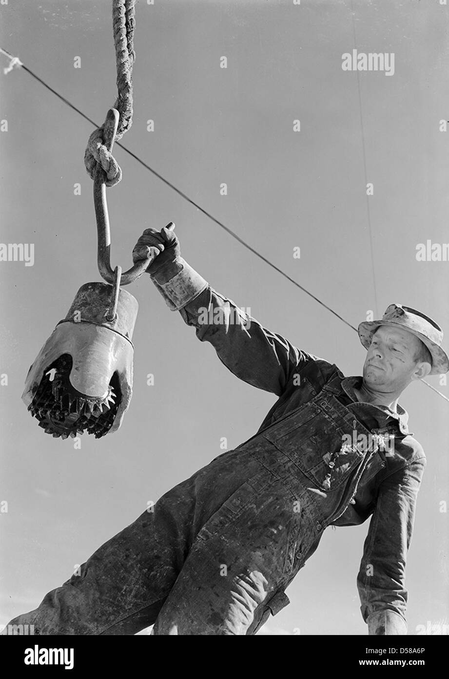 Climax-Molybdenum Co., Swinging a Reed Rock bit to the derrick floor by the Thread protector Stock Photo